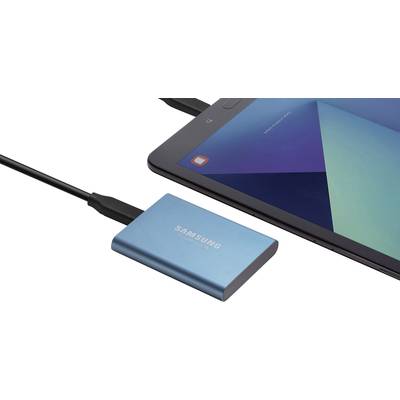 Eine blaue externe Festplatte von Samsung ist über ein USB-Kabel mit einem Tablet verbunden, das ein geometrisches Hintergrundbild zeigt.