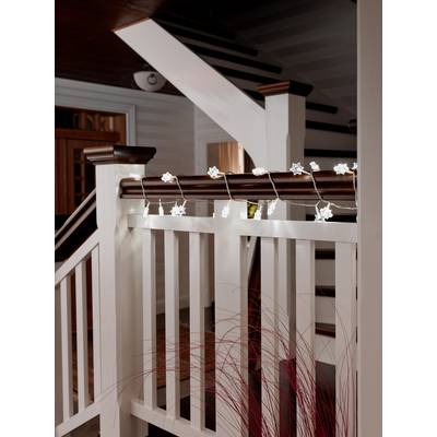 Ein Holzgeländer mit einer Lichterkette in Sternform. Im Hintergrund ist eine Holztreppe zu sehen.