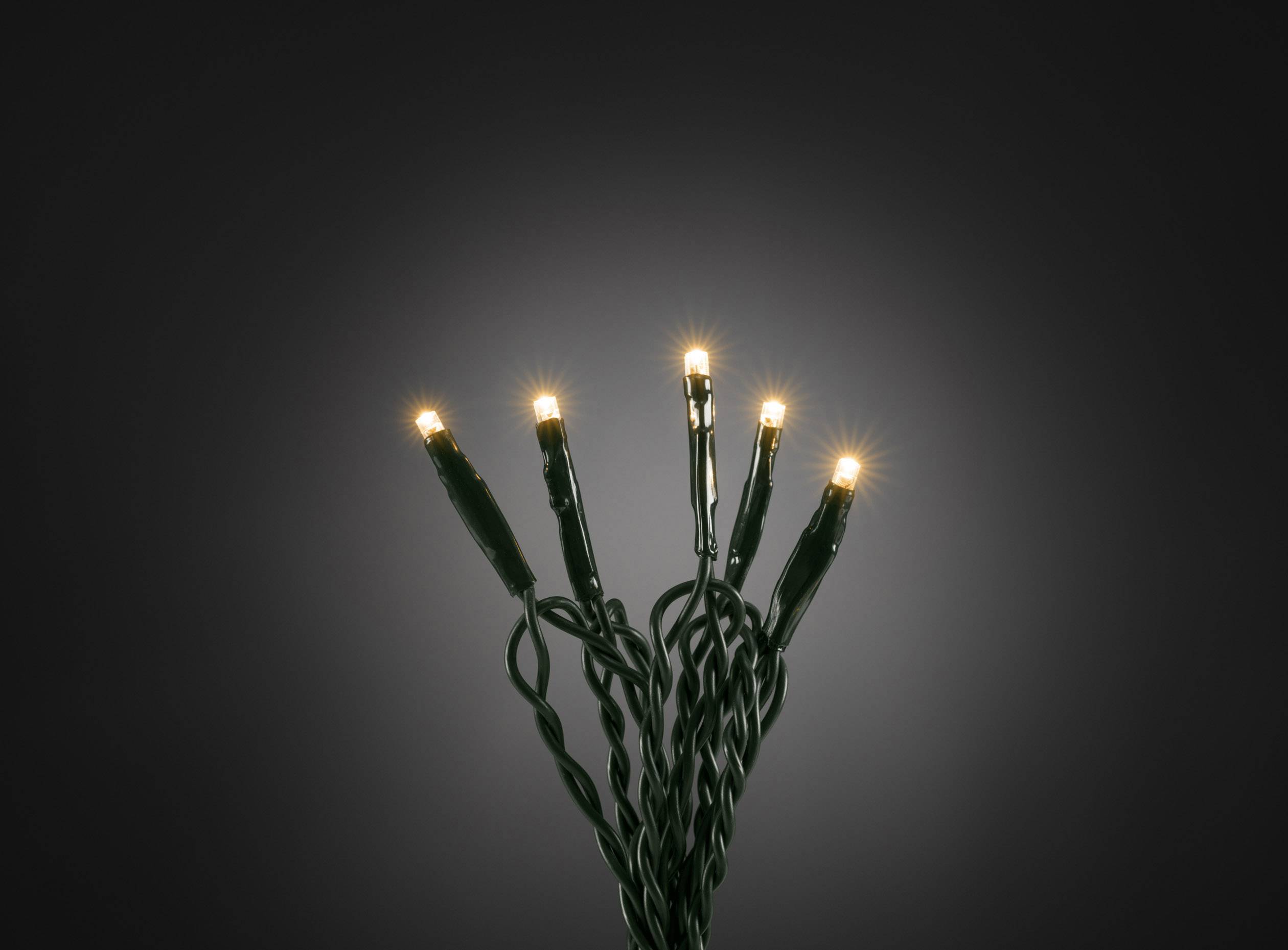 Eine Handvoll leuchtender, warmweißer LED-Lichter mit grünem Kabel vor einem dunklen Hintergrund. Ideal für stimmungsvolle Dekorationen.