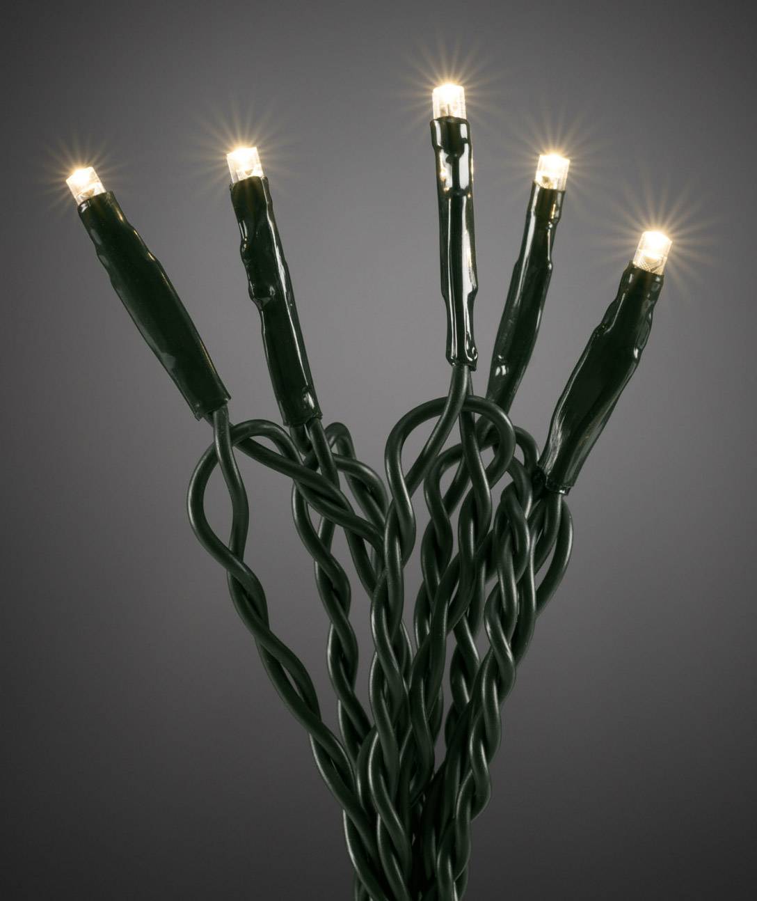 Fünf leuchtende LED-Lichter an grünen Kabeln, leuchten warm auf dunklem Hintergrund.