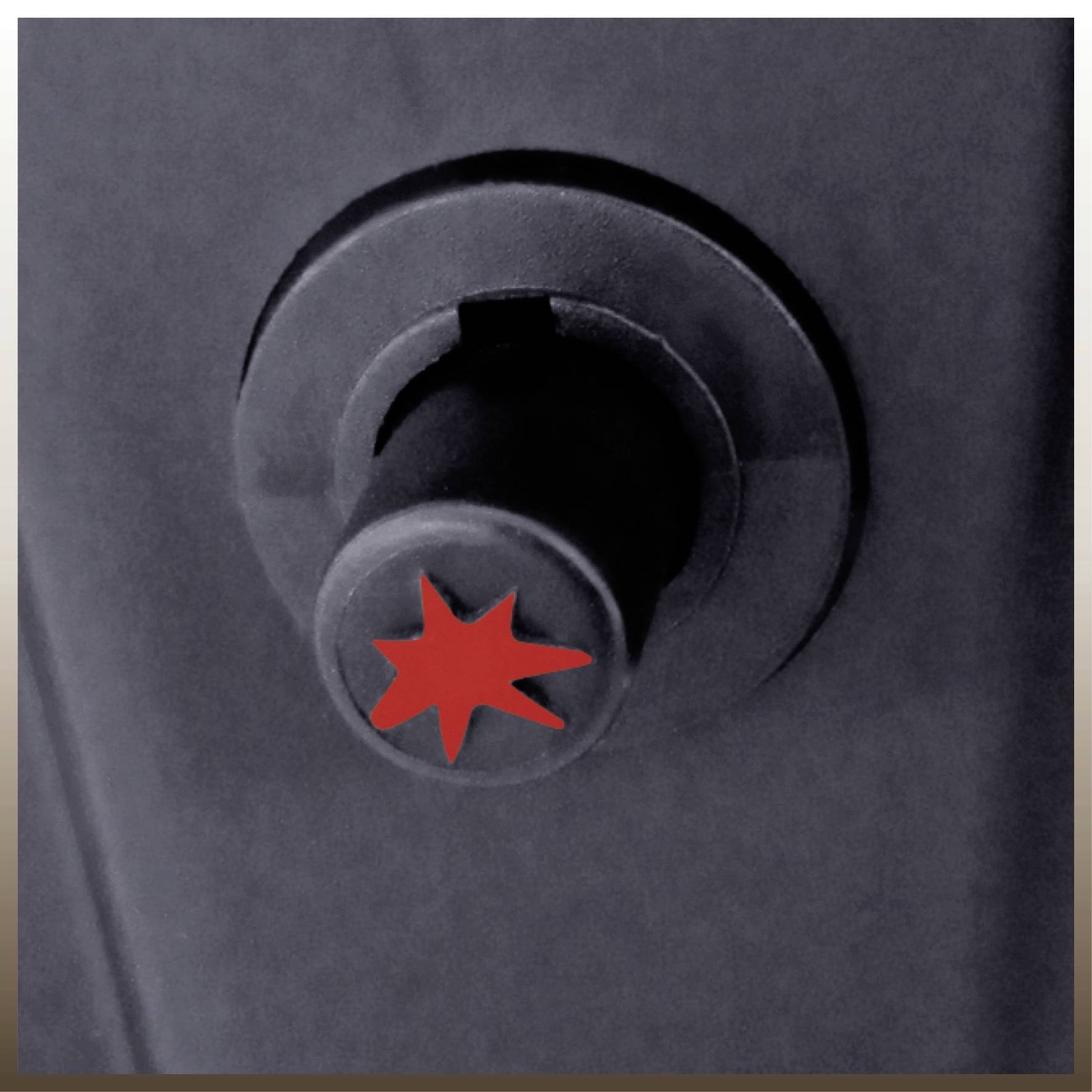 Nahaufnahme eines dunklen Knopfs mit rotem Sternsymbol in der Mitte.