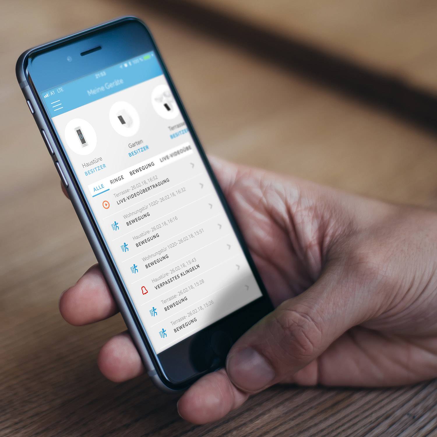 Nahaufnahme eines Smartphones in einer Hand. Auf dem Bildschirm ist eine geöffnete App zu sehen, die Paketzustellungen und deren Status anzeigt.