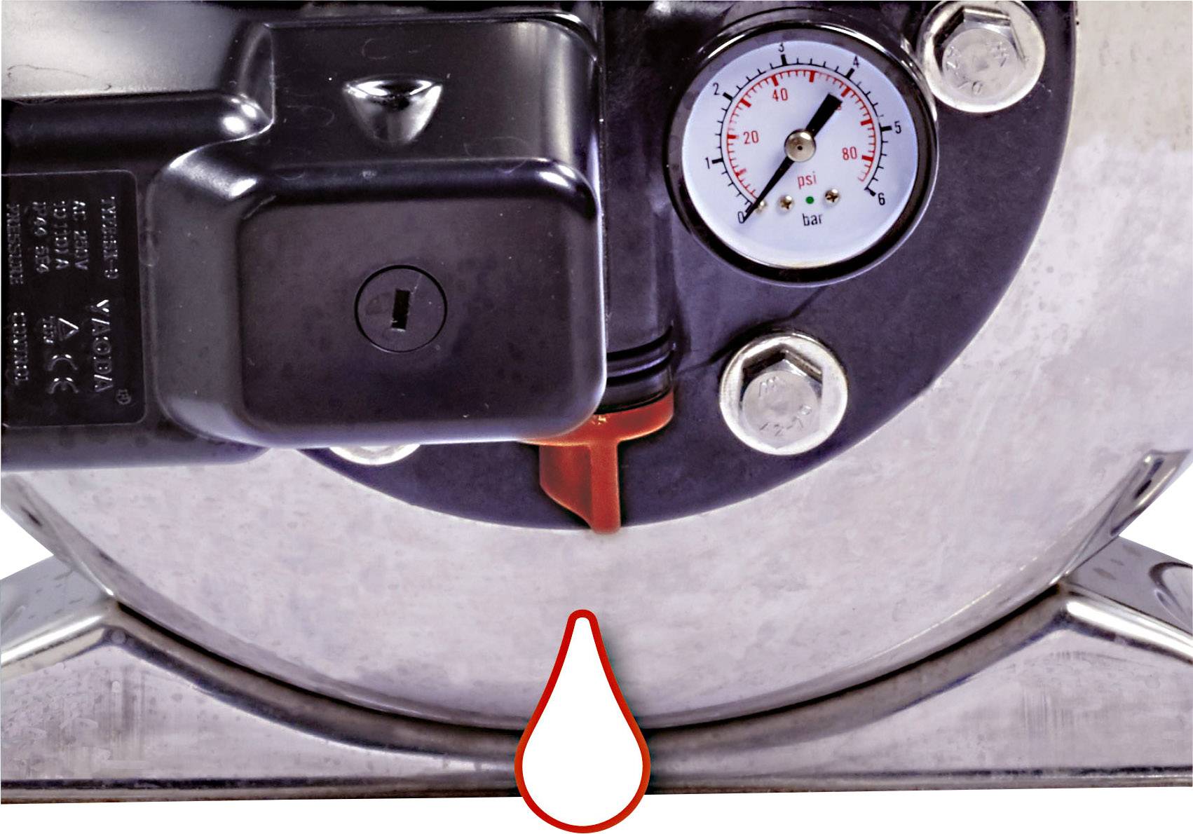 Ein Manometer an einem Maschinenbauteil zeigt den Druck in bar an. Eine rote Markierung und ein Tropfensymbol sind sichtbar.