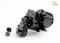 Schwarzes Modellbau-Planetengetriebe mit silberner Kante, schwarzem Zahnrad und kleinen Schrauben daneben, vor weißem Hintergrund.