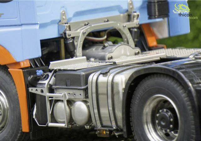 Nahaufnahme eines detaillierten Modell-Lkw, der die Mechanik und Tankstruktur zeigt. Der Lkw ist blau und orange.