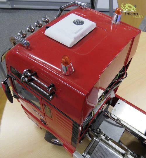 Rotes Modellfahrzeug von oben mit sichtbarer Technik; Dachlichter und Antennen; Modellfahrzeug zeigt detaillierte Verkabelung.