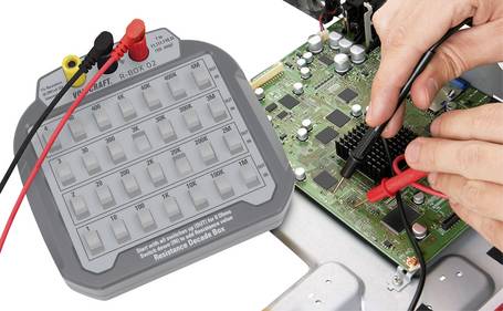Widerstandsdekade (R-Box D2) bei elektronischen Messungen an einer dicht bestückten Leiterplatte.