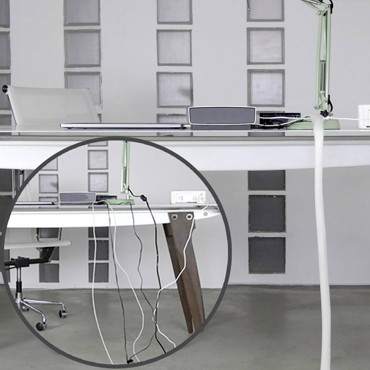 Schreibtisch mit Lampe, Laptop und Lautsprecher, Kabel unter dem Tisch geordnet. Vergrößerter Ausschnitt zeigt Kabelmanagement.