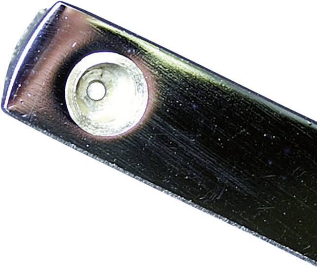 Nahaufnahme eines flachen, dunklen Metallobjekts mit einer silbernen Schraube oder Niete.