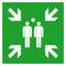 Grünes Schild mit weißen Figuren und Pfeilen, die auf einen zentralen Sammelpunkt für Notfälle hinweisen.