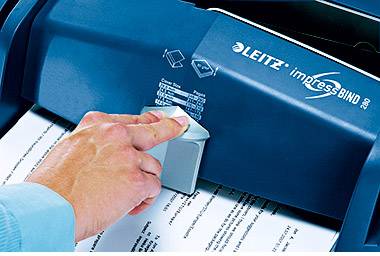 Eine Hand nutzt ein Leitz impressBIND 280 Gerät, um Dokumente zu binden. Der blaue Apparat zeigt Bindungsgrößen auf seiner Oberfläche.
