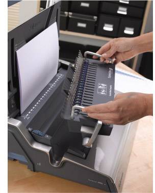 'Person bindet mehrere Blätter Papier mit einem Bindegerät.'