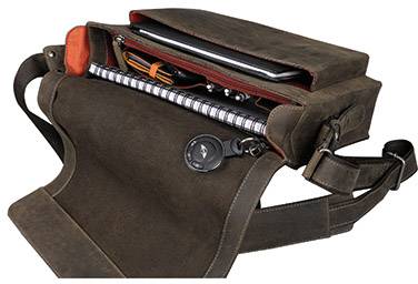 Geöffnete braune Ledertasche mit Laptop, Notizbuch und Stiften im Inneren, zeigt Stauraum und Organisation.