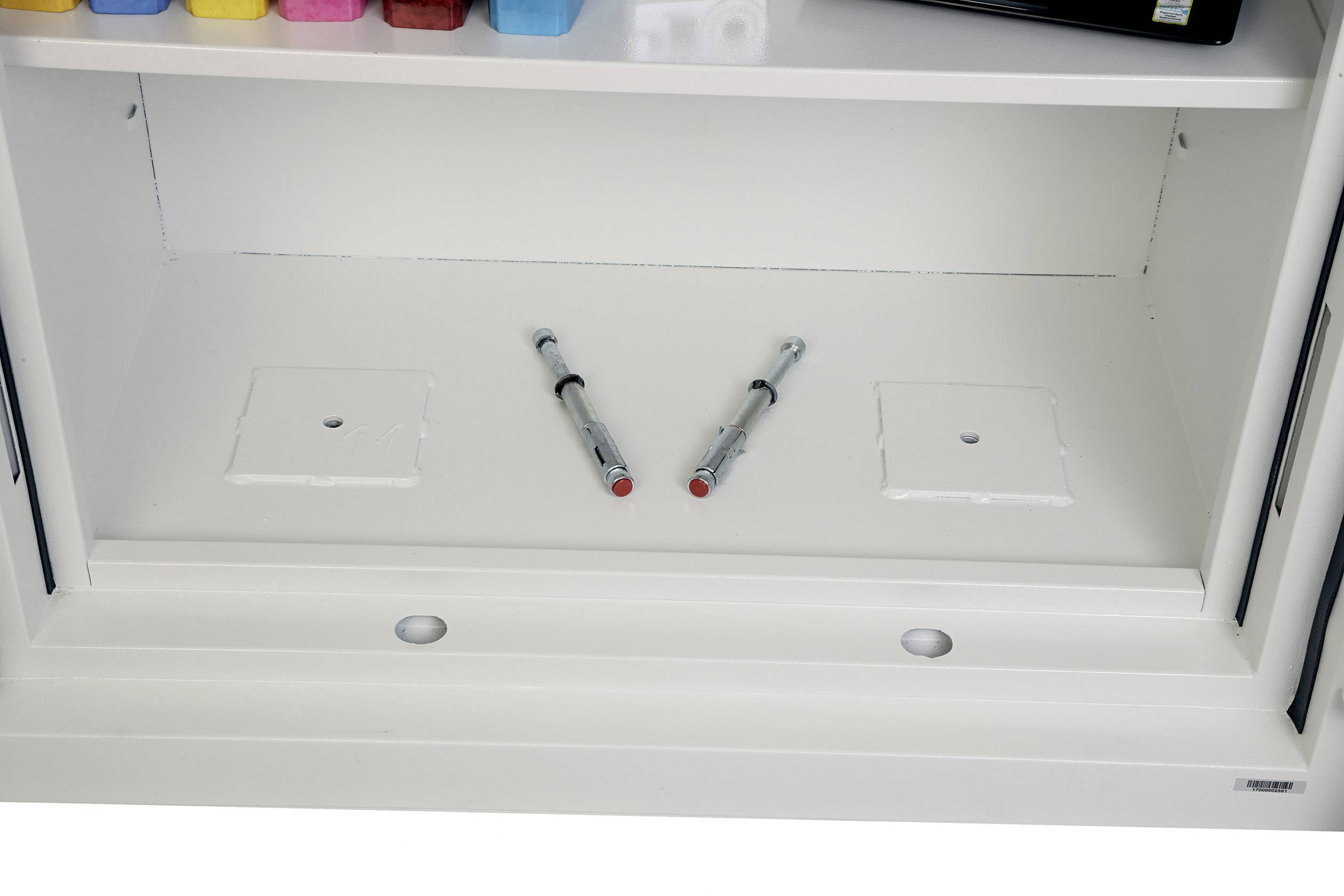 Offener Schrank mit zwei Spritzen auf dem unteren Regal, umgeben von farbigen Behältern.