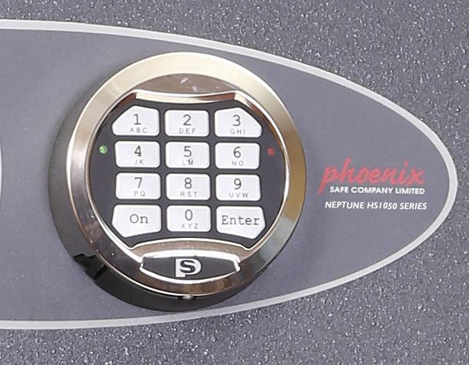 Ein Tresor mit einer Tastatur zur Eingabe von Pins, Marke 'Phoenix Safe Company Limited', Modell 'Neptune HS1050 Series'.