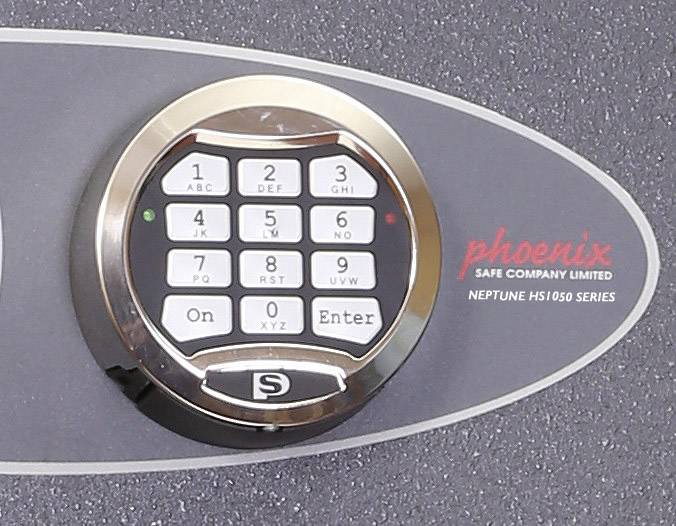 Ein Tresor mit einem elektronischen Zahlenschloss. Links oben sind Kontrollleuchten. Rechts steht 'phoenix' und 'SAFE COMPANY LIMITED'.