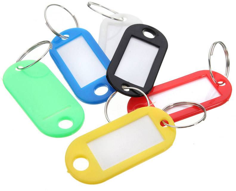 Sechs bunte Schlüsselschilder aus Plastik mit Metallschlüsseln in den Farben Grün, Blau, Weiß, Schwarz, Rot und Gelb.