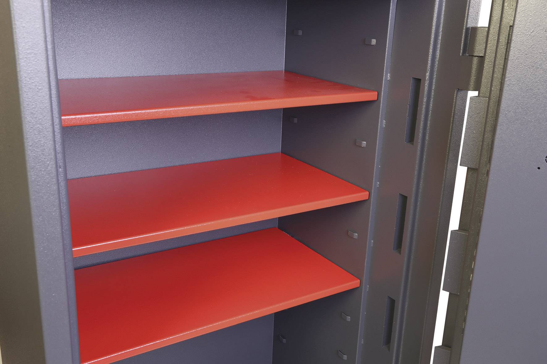 Geöffneter Stahl-Sicherheitsschrank mit drei roten, leeren Regalböden. Schranktür links sichtbar.
