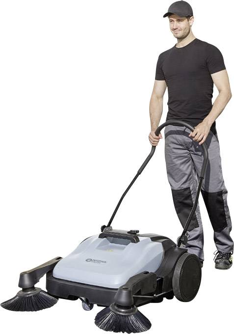 Ein Mann führt eine Straßenkehrmaschine auf einem Bürgersteig. Die Maschine hat zwei große Bürsten an der Vorderseite und ist grau.