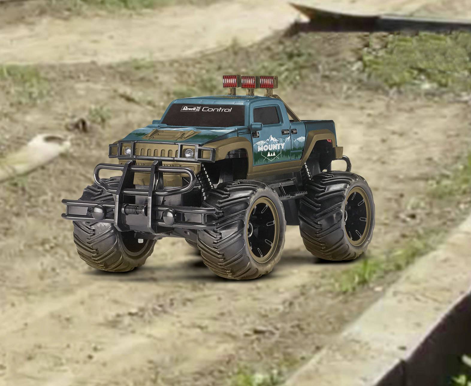 Ein ferngesteuertes Monstertruck-Spielzeug mit großen Reifen fährt auf einer Schotterpiste. Es hat eine blau-grün-schwarze Lackierung.