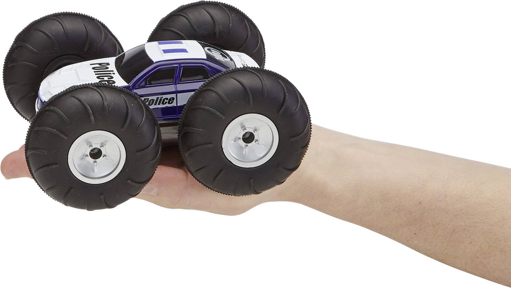 Ein Spielzeug-Monstertruck im Polizeidesign ruht auf einer ausgestreckten Hand. Das Fahrzeug hat große Räder und ist detailreich gestaltet.