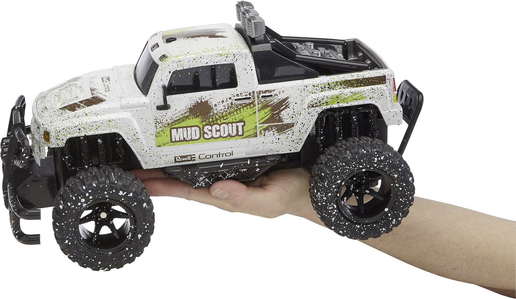 Ein ferngesteuertes Spielzeugauto mit der Aufschrift 'Mud Scout' wird von einer Hand gehalten. Das Auto hat große Profilreifen.
