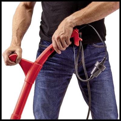 Person hält einen roten Staubsauger in den Händen. Der Staubsauger hat ein schwarzes Kabel.