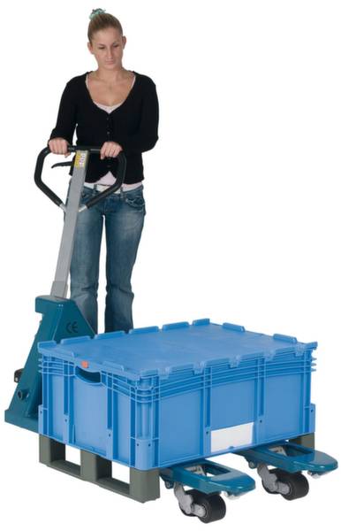 Eine Frau schiebt einen Handhubwagen mit einer großen, blauen Kiste darauf.