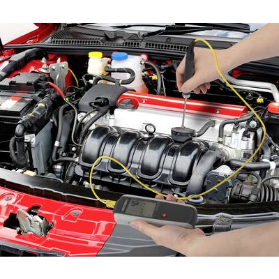 Eine Person misst mit einem elektronischen Gerät die Spannung der Autobatterie unter der offenen Motorhaube eines Autos.