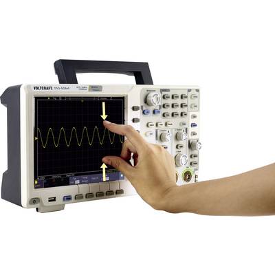 Ein Oszilloskop mit einem Wellendiagramm auf dem Display. Eine Hand zeigt auf den Bildschirm, um bestimmte Messwerte hervorzuheben.