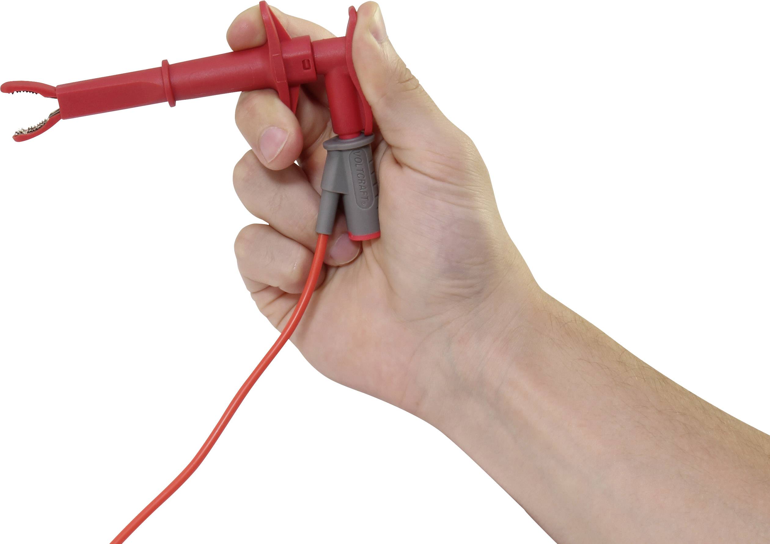 Hand hält einen roten elektrischen Testgriff mit Kabel.