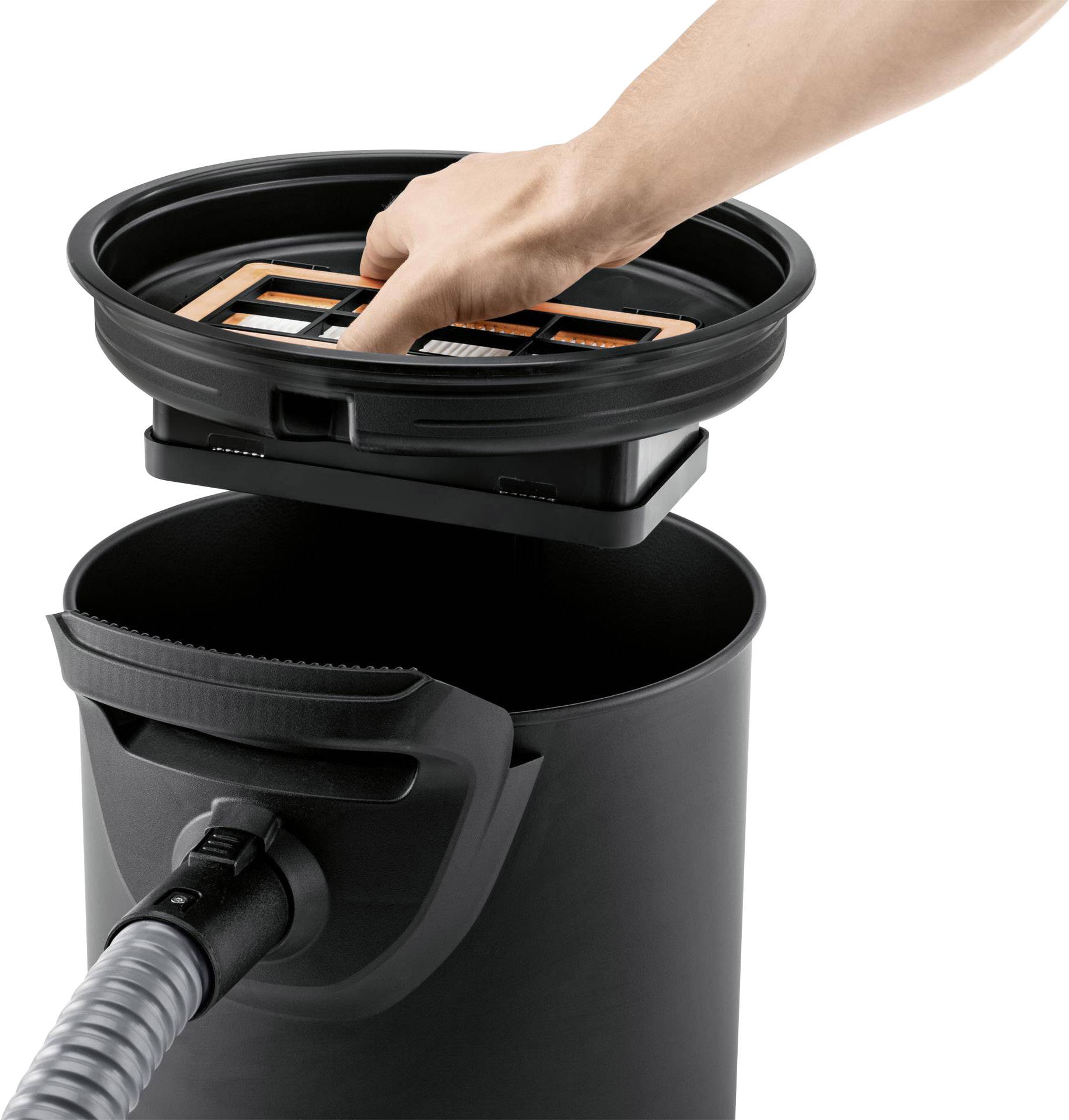 Eine Hand entfernt einen Filter aus einem schwarzen Staubsaugerbehälter. Ein Staubsaugerschlauch ist an der Vorderseite angeschlossen.