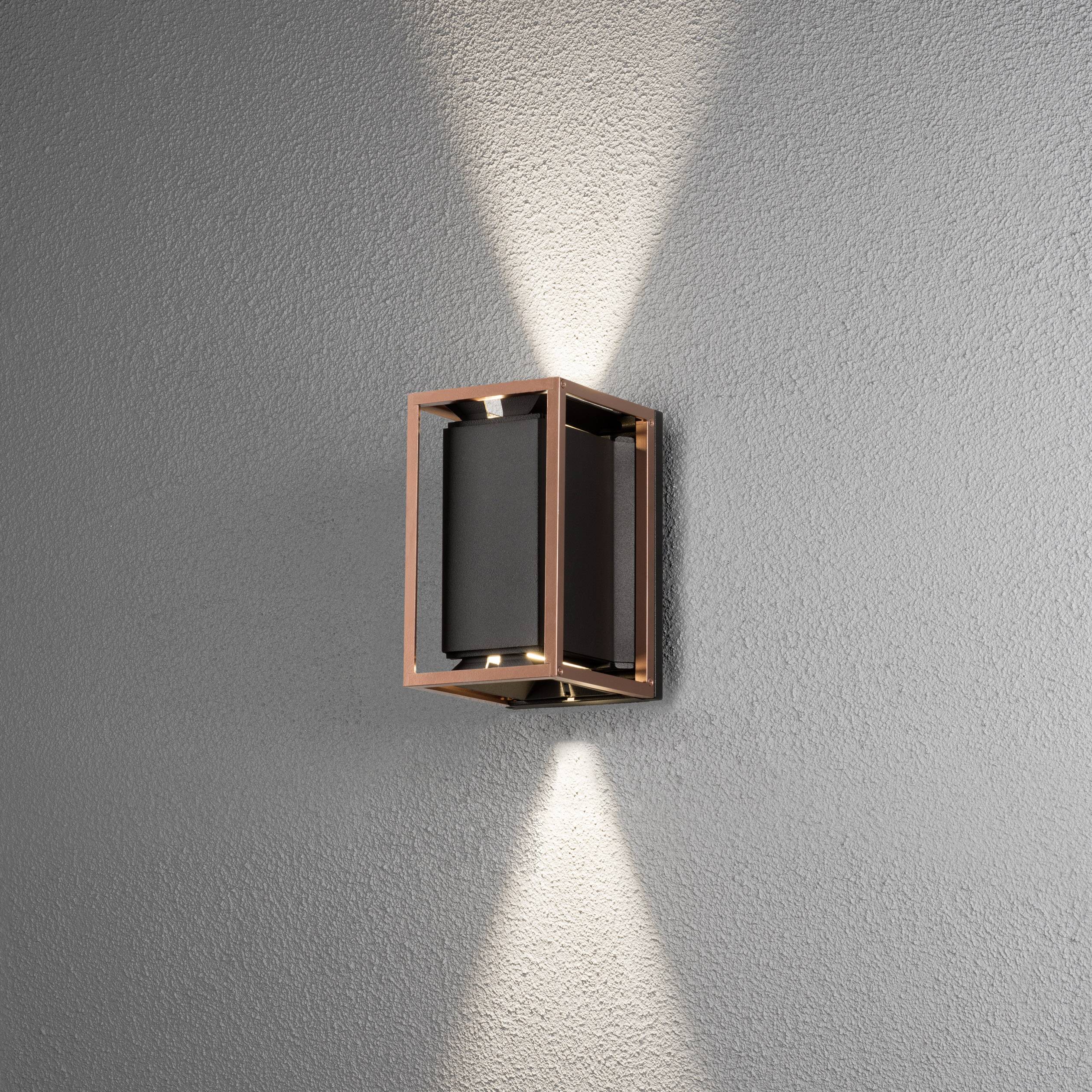 Wandleuchte mit modernem, rechteckigem Design, wirft Lichtstrahlen nach oben und unten an eine graue Wand.