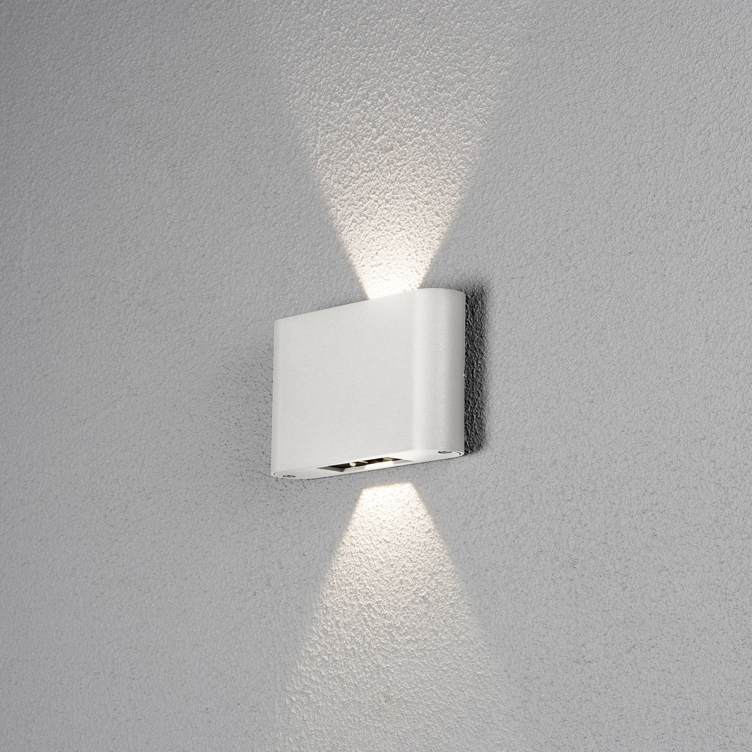 Weiße, rechteckige Wandleuchte an grauer Wand, strahlt Licht nach oben und unten.