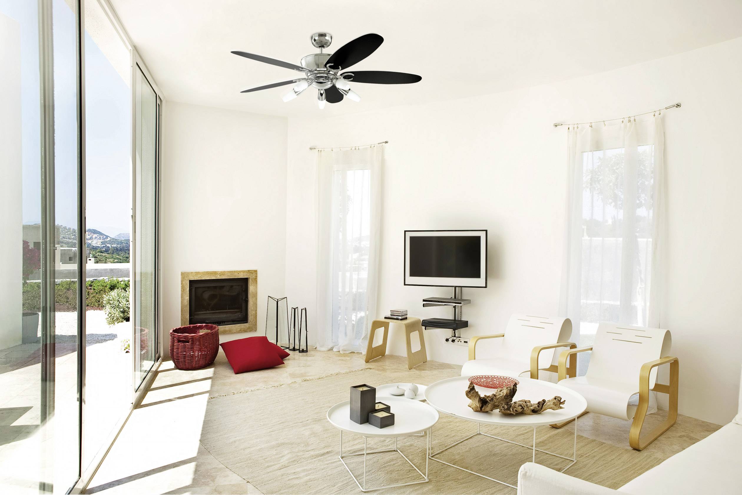 Helles Wohnzimmer mit moderner Einrichtung, weißem Sofa, Fernseher an der Wand, Kamin und großen Fenstern, die viel Licht hereinlassen.