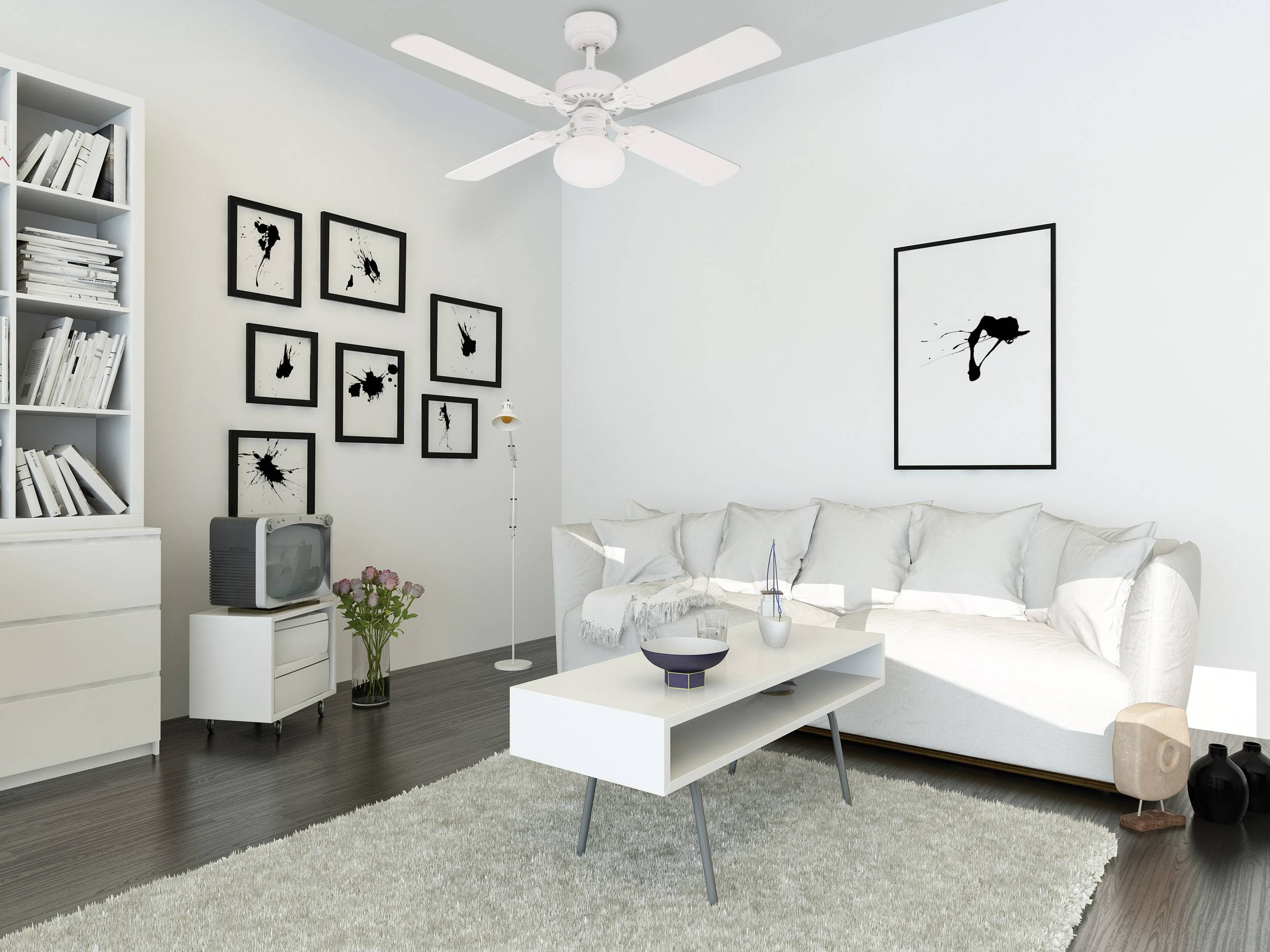 Ein modernes Wohnzimmer mit einem weißen Sofa, einem weißen Couchtisch und Wandkunst. Ein Deckenventilator hängt über dem Raum.