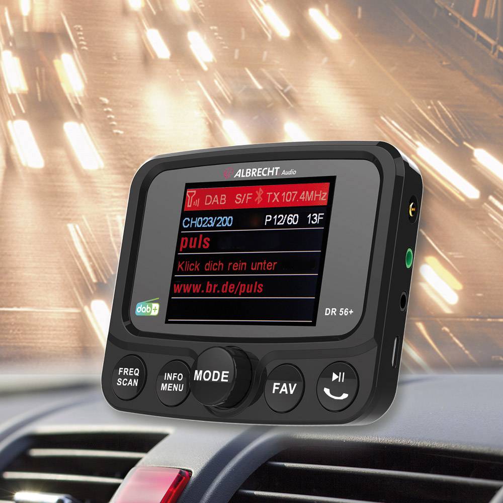 Ein digitales Radiogerät im Auto-Armaturenbrett zeigt 'Ch02/200' und 'DAB' auf dem Bildschirm an. Im Hintergrund unscharfe Lichter.