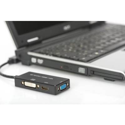 Ein Laptop, an den ein Adapter mit HDMI-, DVI- und VGA-Anschlüssen angeschlossen ist, liegt auf einem Tisch.