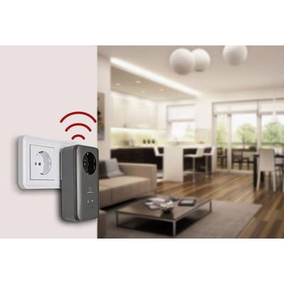 Intelligenter Stecker in Wohnwand; sendet WLAN-Signale. Modern eingerichtetes Wohnzimmer mit Sofa und Küchenzeile im Hintergrund.