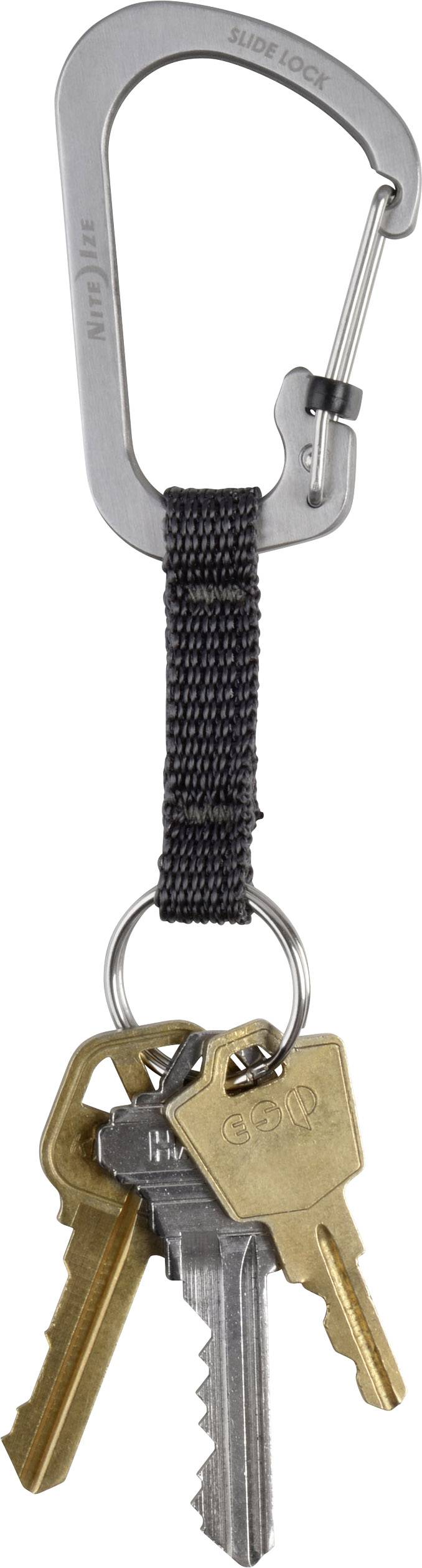 Ein silberner Karabiner mit schwarzem Band hält vier metallene Schlüssel, darunter zwei goldene und zwei silberne.