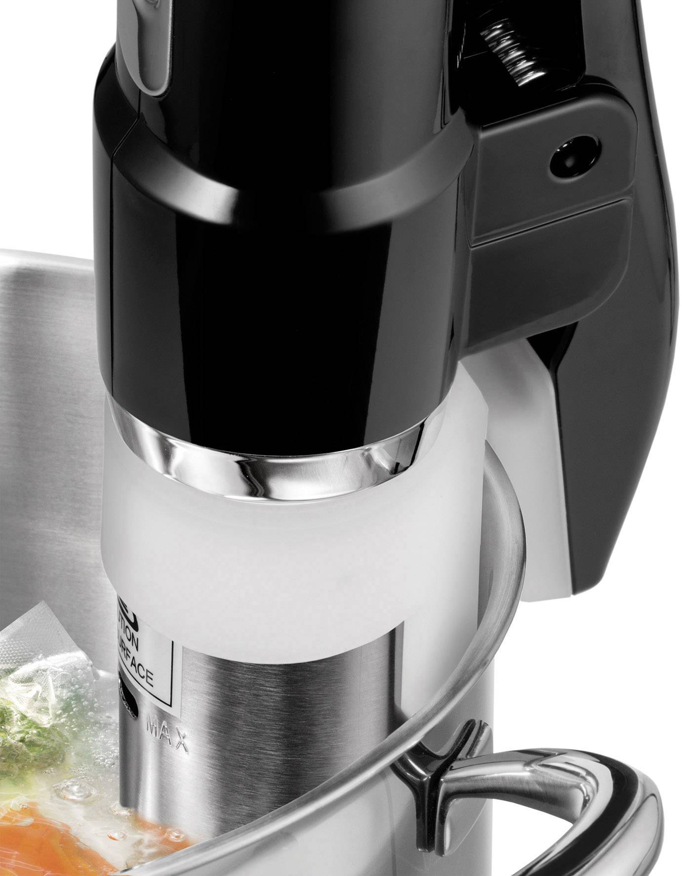 Ein schwarzer Immersion-Zirkulator wird in einem Edelstahlbecken verwendet, um vakuumversiegelte Lebensmittel im Sous-vide-Verfahren zu garen.