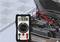 Ein Multimeter zeigt 4,38 Volt an, während es mit einem Autoakkumulator verbunden ist. Ein rotes und ein schwarzes Messkabel sind angeschlossen.