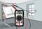 Ein digitales Multimeter zeigt '11,86' an, während es mit einem roten und schwarzen Kabel an ein Messgerät angeschlossen ist; im Hintergrund ein Zeichentisch.