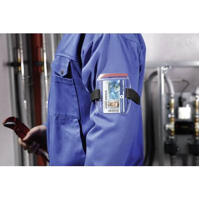 Ein Arbeiter in blauer Uniform trägt eine Ausweishülle mit Foto am linken Oberarm, während er in einem technischen Raum arbeitet.