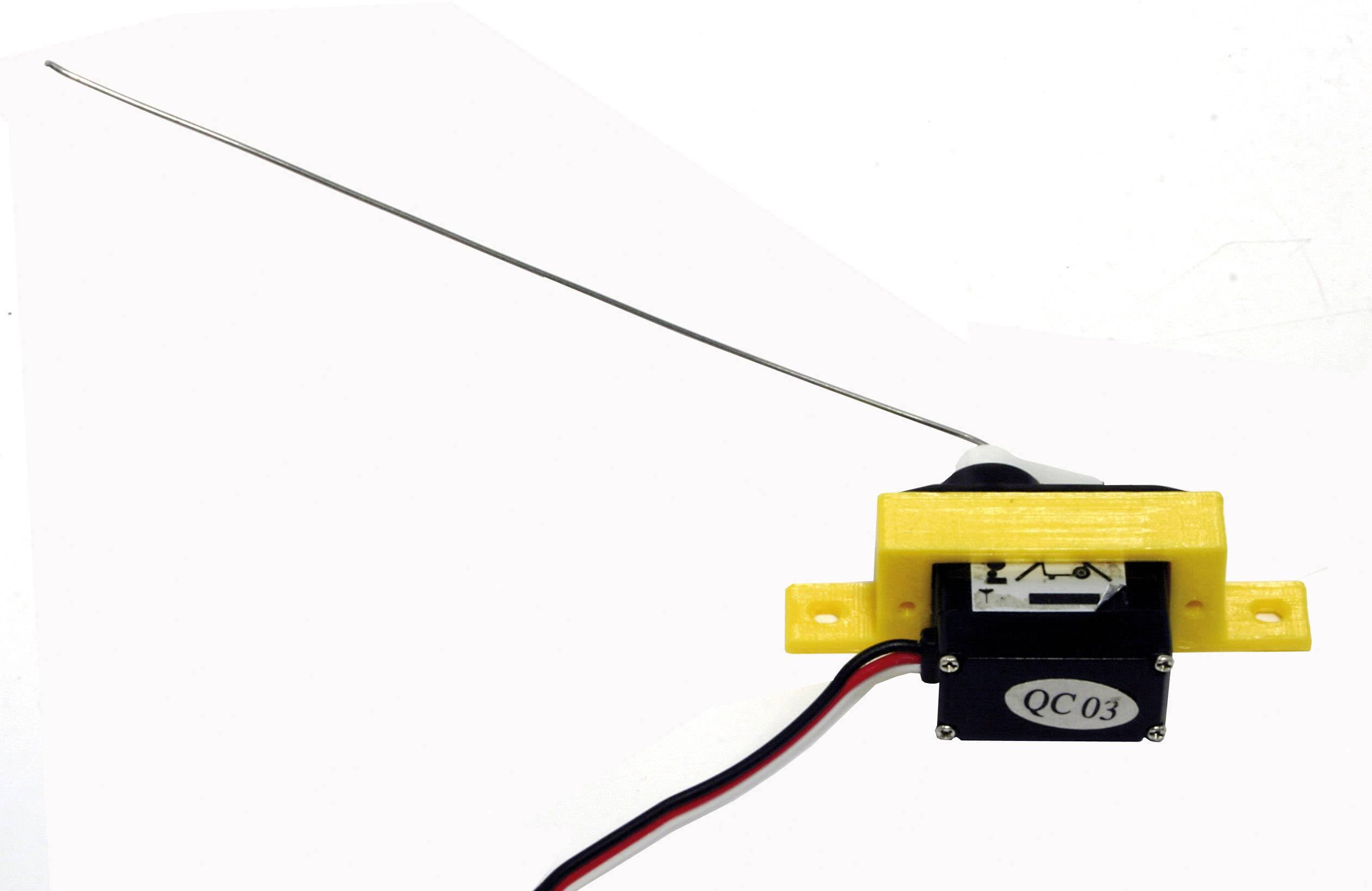 Ein gelbes mechanisches Bauteil mit einer dünnen Metallstange und zwei Drähten, vermutlich ein Servomotor mit Antenne.