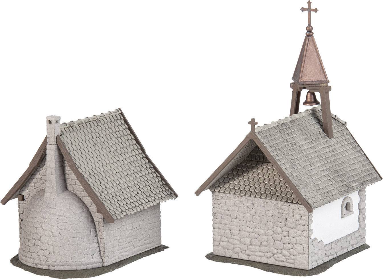 Zwei Modellhäuser aus Steinimitat, jeweils mit ziegelgedecktem Dach. Eines hat einen Glockenturm mit Kreuz, das andere einen runden Kamin.