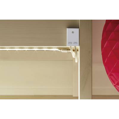 Unter einem Tisch ist eine LED-Lichtleiste montiert. Neben der Lichtleiste befindet sich ein rotes, strukturiertes Objekt.