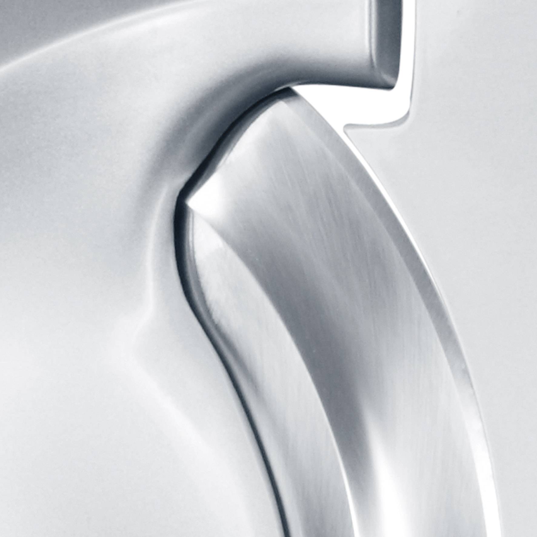 Nahaufnahme einer silbernen Metalloberfläche mit glatter, gebogener Struktur.