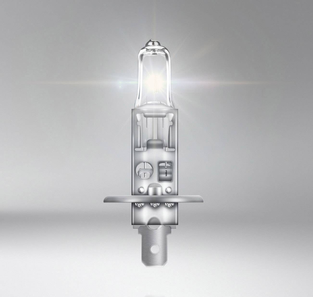 Eine leuchtende Halogenlampe, die in einem grauen Raum schwebt, lenkt den Fokus auf ihre komplexe innere Struktur und das ausgestrahlte Licht.