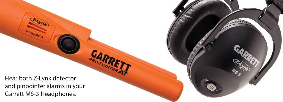 'Oranges Gerät mit Aufschrift "Garrett Pro-Pointer AT". Rechts schwarze Kopfhörer mit Aufschrift "Garrett MS-3". Text: "Hear both Z-Lynk detector and pinpointer alarms in your Garrett MS-3 Headphones."'